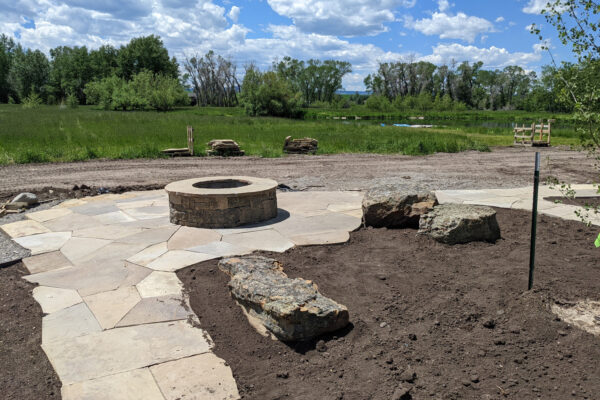 Montana flagstone patio with fire pit by trout pond in Bozeman Montana