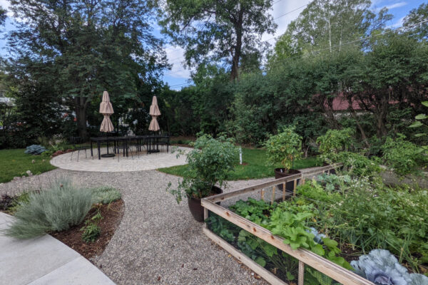 Outdoor paver patio dining space with vegetable gardens in downtown Bozeman