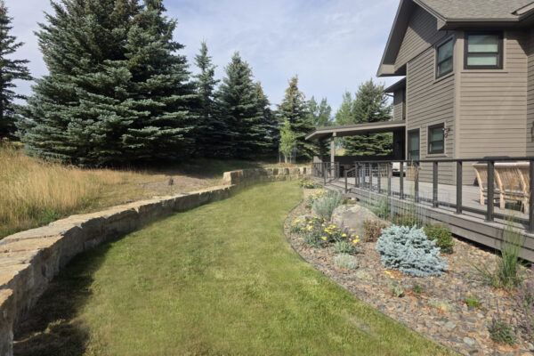 Boulder Retaining Wall In South Bozeman Landscaping Project that includes Drought Tolerant Plantings and Moss Boulders